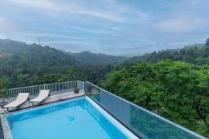 a swimming pool on a balcony with mountains in the background at Rivendell Hotel in Kandy