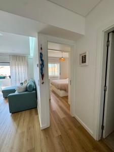 a living room with a blue couch and a bed at Casa Oceano 59 in Costa da Caparica +10 photos