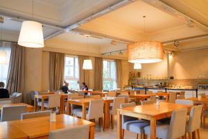 a restaurant with wooden tables and chairs and people in the background at Facón Del Mar Hotel in Mar del Plata