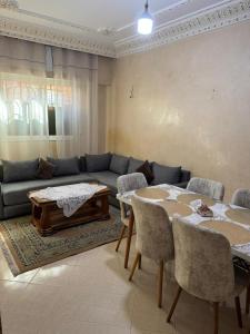 a living room with a couch and a table and chairs at maison soleil in Nouaceur