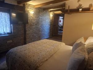 a bedroom with a bed and a tv on a brick wall at Chalet la dimora di Barbara in San Barnaba