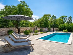 a chair and an umbrella next to a swimming pool at Villa Dream by Interhome in Dobrinj