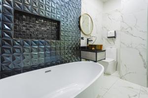 a white bathroom with a tub and a mirror at HOTEL MONTANA in Bello