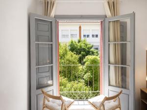 a room with a window with two chairs and a view at Pensión Bandrés Huesca Centro in Huesca