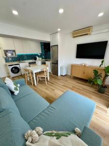 a living room with a blue couch and a kitchen at Casa Oceano 59 in Costa da Caparica