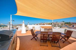 a patio with a table and chairs on a roof at BeGuest Ferragudo Sunny Apartment in Ferragudo