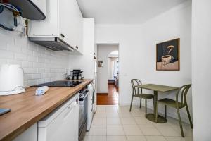 a kitchen with white appliances and a table and chairs at BeGuest Ferragudo Sunny Apartment in Ferragudo