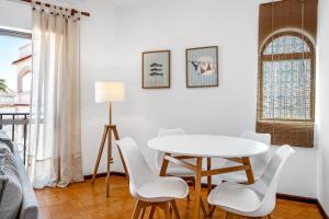 a white dining room with a white table and chairs at BeGuest Ferragudo Sunny Apartment in Ferragudo +9 photos