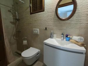 a bathroom with a sink and a toilet and a mirror at Seaside Apartments Sunny Prižba in Blato +64 photos