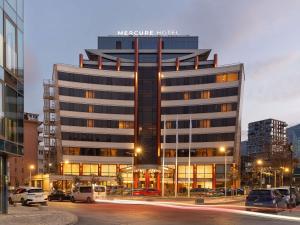 a hotel building with cars parked in front of it at Mercure Sofia City in Sofia