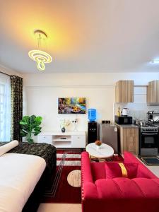 a living room with a red couch and a kitchen at Ethanira Homes Ngara in Nairobi