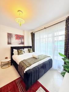 a bedroom with a bed and a large window at Ethanira Homes Ngara in Nairobi
