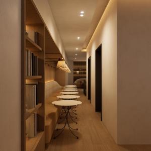 Eine Reihe von Tischen in einem Raum mit Bücherregalen in der Unterkunft Little Something Hotel NYC in New York