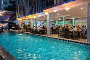 a pool in a restaurant with people sitting at tables at Vang Vieng Dragon House in Vang Vieng