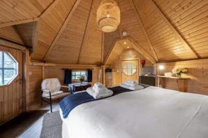a bedroom with a large bed in a wooden room at Scald Law Cabin in Kirknewton