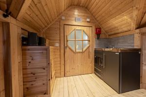 a kitchen with a door in a wooden cabin at Scald Law Cabin in Kirknewton