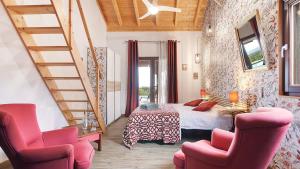 a bedroom with a bed and two pink chairs at Chambres d'hôtes Naturistes (Nudiste) "Cabanadelsol" - Adults Only in Monte da Charneca +67 photos