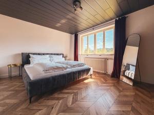 a bedroom with a bed and a large window at Doras Ferienhaus in Bad Reichenhall