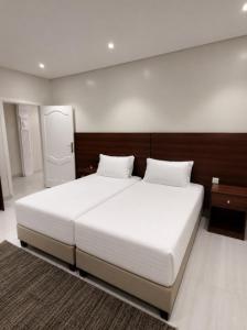 a bedroom with a large white bed with two pillows at OrbitNet - Anwarat in Medina