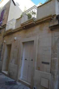 a building with a white door and a balcony at Casa Ferrante in Lecce