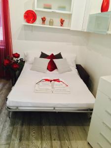 a bedroom with a white bed with red bows on it at B&S Suite Colosseo in Rome