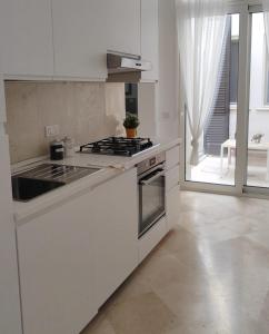 a kitchen with white cabinets and a stove top oven at Casa Ferrante in Lecce