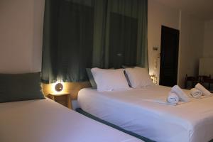 two beds sitting next to each other in a bedroom at Raptis Aparthotel Sivota in Syvota