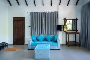 a living room with a blue couch and a table at Ella Blue Heaven in Ella