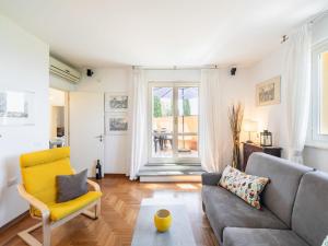 a living room with a couch and a yellow chair at Apartment Villa Elisa by Interhome in Castellina in Chianti