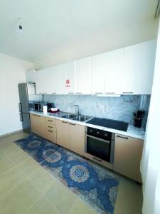 a kitchen with white cabinets and a sink at Olive GREEN house in Durrës