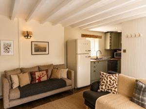 a living room with a couch and a refrigerator at Abbey Cottages Buzzards Watch in Talley