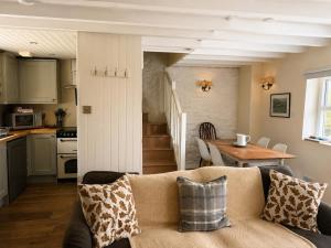 a living room with a couch and a table and a kitchen at Abbey Cottages Buzzards Watch in Talley +23 photos