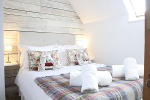 a bedroom with a large white bed with pillows at Abbey Cottages Buzzards Watch in Talley