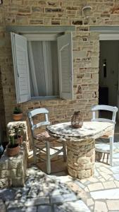 a patio with a table and chairs and a stone wall at Villa Sylvia 1 in Matala +62 photos