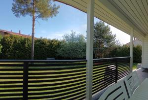 a screened porch with a fence and a tree at Huilikammari in Seinäjoki