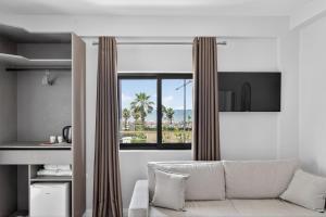 a living room with a couch and a window at Casa Del Sol Seaside Hotel in Durrës
