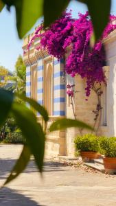 a building with purple flowers on the side of it at La Serra - Villa De Bonis in San Cesario di Lecce