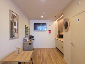 a living room with a table and a kitchen at AL Ponto Norte in Melgaço
