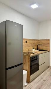 a kitchen with a stainless steel refrigerator and a sink at Apartmani SARA Bugojno in Bugojno