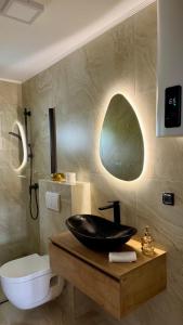 a bathroom with a black sink on a wooden table at Apartmani SARA Bugojno in Bugojno +32 photos