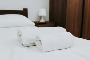 two white towels are stacked on a bed at Złota Brama - Old Town Apartament 2 in Gdańsk