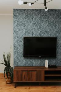 a flat screen tv sitting on top of a entertainment center at Złota Brama - Old Town Apartament 2 in Gdańsk