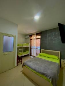 a bedroom with a large bed and a television at Hotel Ylberi in Golem