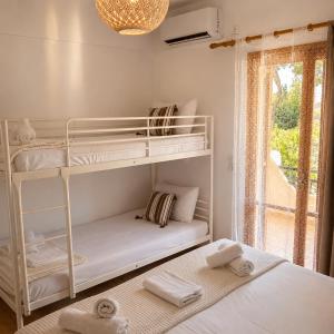a bedroom with two bunk beds and a window at FILOXENIA by Evita's Resort in Poros