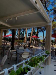 a patio with tables and chairs and potted plants at Hotel Ylberi in Golem +8 photos