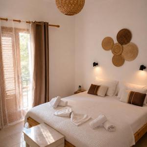 a bedroom with two beds with towels on them at FILOXENIA by Evita's Resort in Poros