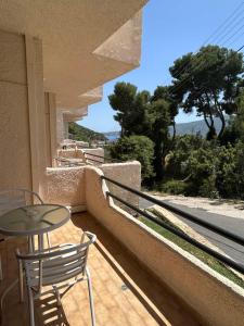 a patio with a table and chairs on a balcony at FILOXENIA by Evita's Resort in Poros