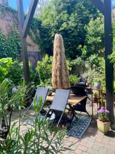 a patio with two chairs and a table and an umbrella at Kamoro in Trier