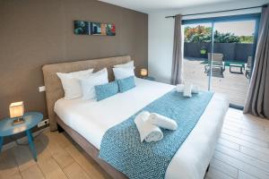 a hotel room with a bed and a balcony at Résidence Pierre & Vacances Premium Vesna Rossa in Porto-Vecchio