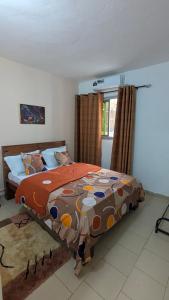 a bedroom with a large bed with a colorful comforter at LANISCA'S Home in Yaoundé